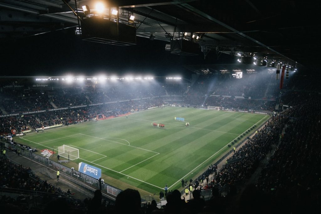 Football stadium under floodlights at kick-off