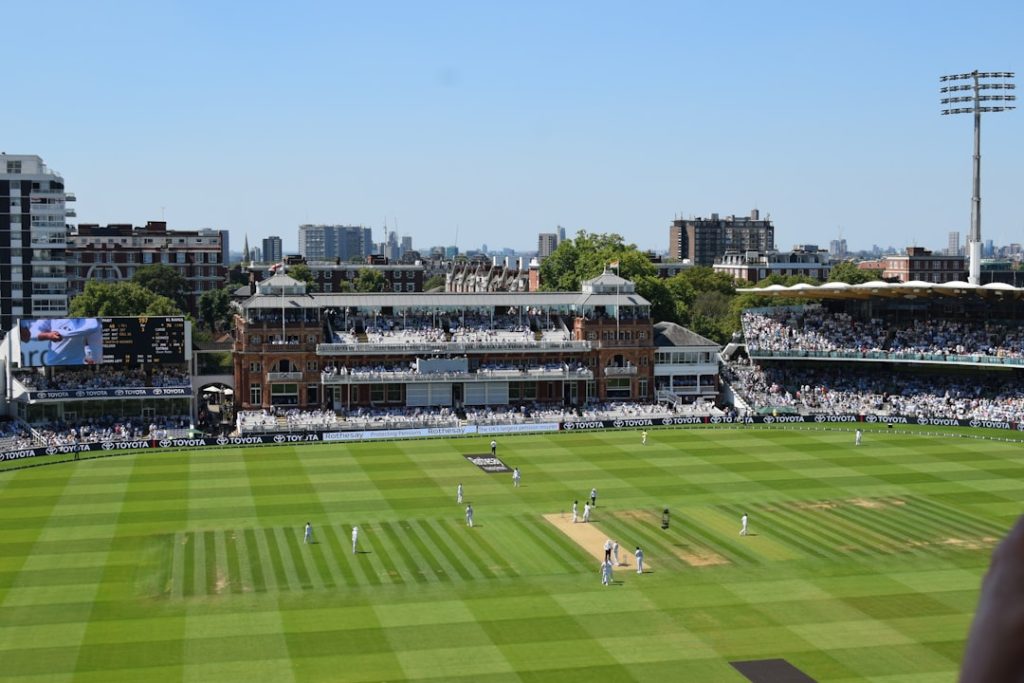 A cricket match under way at a sunny stadium
